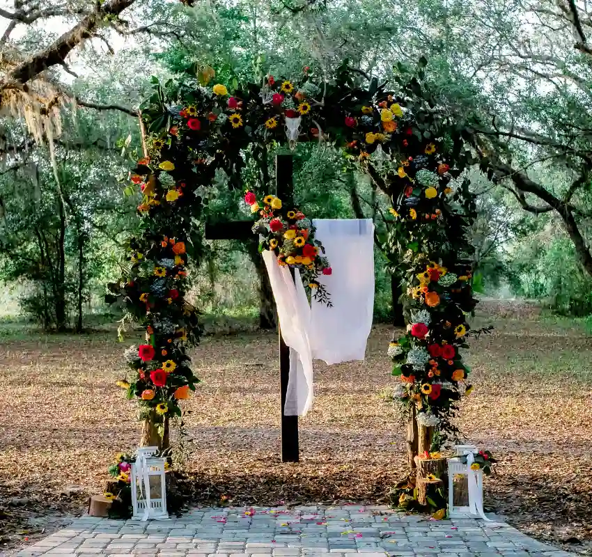 Fall barn wedding arch with sunflowers, autumn florals, and white drapes at Legacy at Oak Meadows.